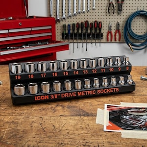 Op de afbeelding: Een zwarte kunststof organizer met een set zilverkleurige ICON 3/8" aandrijf-doppen. De doppen zijn gerangschikt in twee rijen met rood gedrukte cijfers van 8 tot 19 en de tekst ICON 3/8" DRIVE METRIC SOCKETS op de voorzijde.
