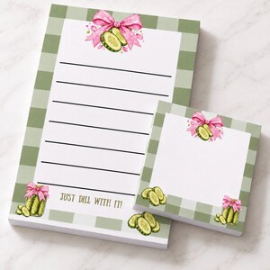 May include: A rectangular notepad and a square sticky note pad featuring a sage green and white gingham border. Both pads display watercolor illustrations of pickle jars with pink bows and sliced pickles. The notepad includes the text JUST DILL WITH IT!
