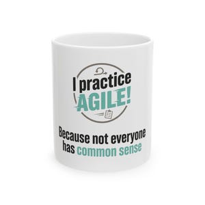 May include: A white ceramic mug featuring the black and teal text I practice AGILE! Because not everyone has common sense. The design includes a circular graphic with a small clipboard icon and an arrow symbol above the word AGILE.