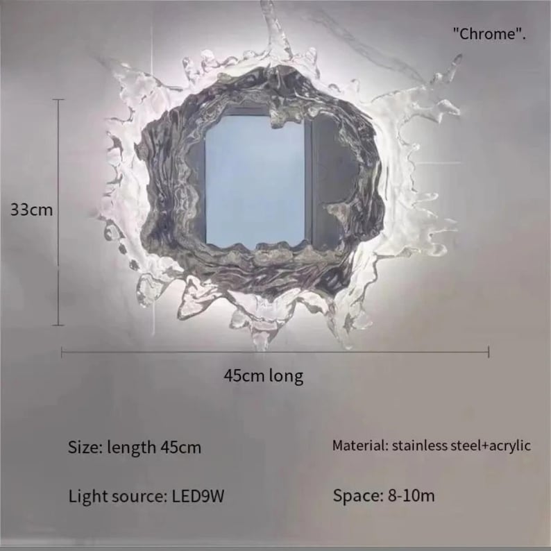 Gold finish water splash mirror wall light with an organic sculptural shape, acrylic mirror center, and integrated LED illumination.