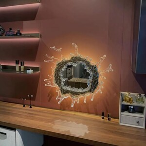 Complete wall-mounted water splash mirror light showing its acrylic mirror, stainless steel body, splash-inspired design, and integrated LED lighting.
