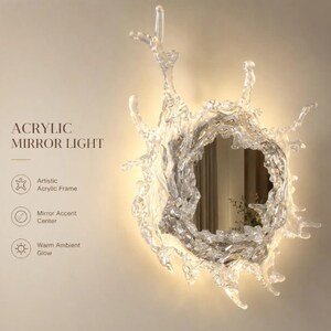 Detailed view of the reflective acrylic mirror surrounded by the sculptural water splash frame and integrated LED lighting.