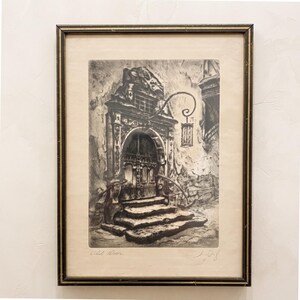 May include: A framed black and white etching depicting an ornate arched doorway with stone steps and a hanging lantern. The print is titled Old Door in the bottom left corner and features a handwritten signature in the bottom right corner.