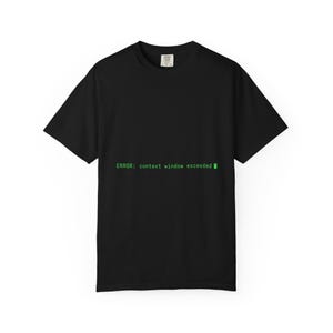 Op de afbeelding: Een zwart t-shirt met korte mouwen en de groene tekst "ERROR: context window exceeded" op het midden van de borst. Het shirt heeft een ronde hals en een standaard pasvorm, met een klein wit merklabel zichtbaar bij de binnenkraag.