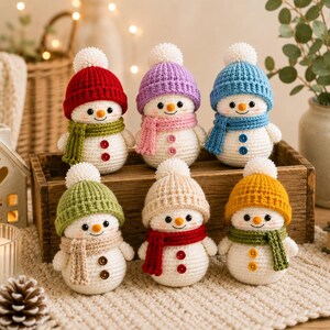 Peut inclure: Six petites figurines de bonhommes de neige au crochet, chacune portant un bonnet en tricot color&eacute; avec un pompon blanc et une &eacute;charpe assortie. Les bonhommes de neige ont un corps blanc, un nez orange, des yeux noirs et deux boutons.