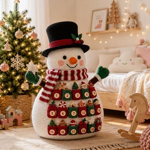 May include: A large, white, crocheted snowman advent calendar featuring a black top hat with a red band, a striped red and white scarf, and green mittens. The snowman has twenty small, numbered pockets in red and green, each containing a tiny ornament.