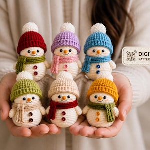 Peut inclure: Six petits bonhommes de neige au crochet avec des corps blancs, des nez orange et des yeux noirs. Chacun porte un bonnet en tricot color&eacute; avec un pompon blanc et une &eacute;charpe assortie. Deux boutons ornent chaque torse. Une &eacute;tiquette indique DIGITAL PATTERN ONLY.