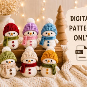 Peut inclure: Six bonhommes de neige au crochet avec des corps blancs, portant chacun un bonnet et une &eacute;charpe de couleur unique avec deux boutons sur le devant. Le texte DIGITAL PATTERN ONLY et une ic&ocirc;ne PDF apparaissent sur la droite.