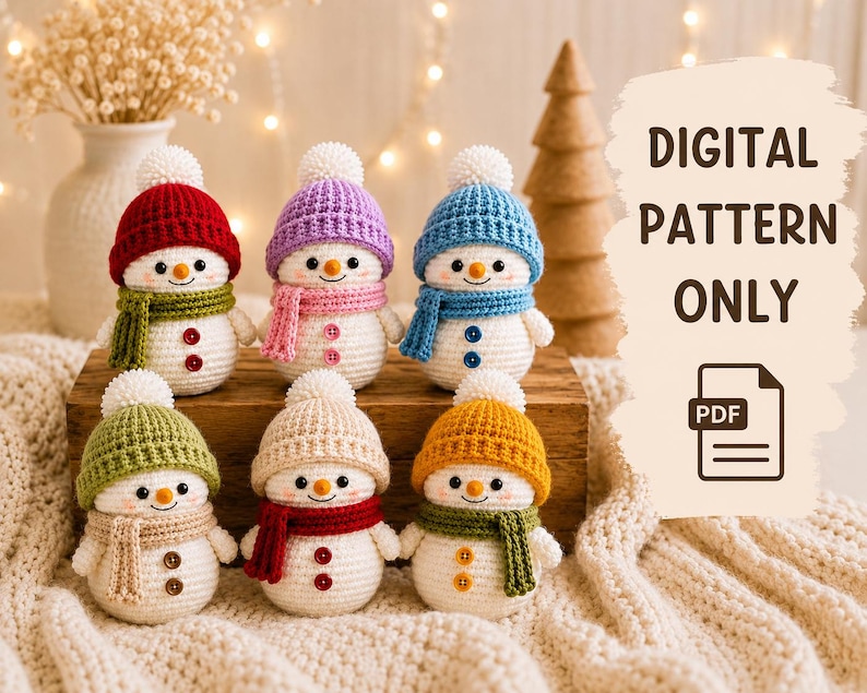 Peut inclure: Six bonhommes de neige au crochet avec des corps blancs, portant chacun un bonnet et une &eacute;charpe de couleur unique avec deux boutons sur le devant. Le texte DIGITAL PATTERN ONLY et une ic&ocirc;ne PDF apparaissent sur la droite.