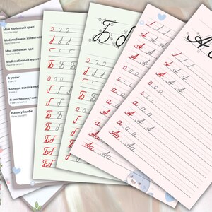 Op de afbeelding: Een set educatieve werkbladen voor het leren van het Russische alfabet, met gelinieerde oefenpagina's met rode en zwarte cursieve letters, illustraties van een haai en een bij, en een groene draak in de hoeken van de pagina's.