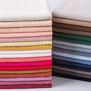 Puede incluir: Dos pilas de cuadrados de tela doblados dispuestos en cuadrícula. La pila izquierda presenta tonos cálidos que incluyen blanco, crema, rosa, amarillo, rojo, naranja y morado. La pila derecha muestra tonos fríos y neutros como gris, marrón, verde y azul.