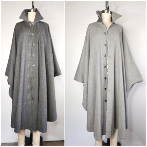 May include: Two gray wool capes with button closures and a high collar. The capes are lined with a lighter gray fabric.