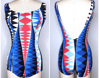 May include: A blue, red, white, and black geometric patterned swimsuit with a low back.
