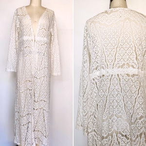 Peut inclure: Un cardigan blanc à manches longues en crochet avec un col en V profond et une fermeture éclair. Le cardigan présente un motif de dentelle délicat.