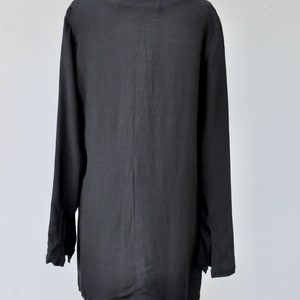 May include: A black long-sleeved shirt with a V-neck and a relaxed fit.