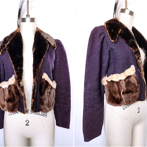 May include: A purple cropped jacket with a brown fur collar and pockets. The jacket has a button closure and is lined with a brown fur.