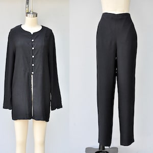 May include: A black long-sleeved shirt with a button-up front and a black pair of pants.