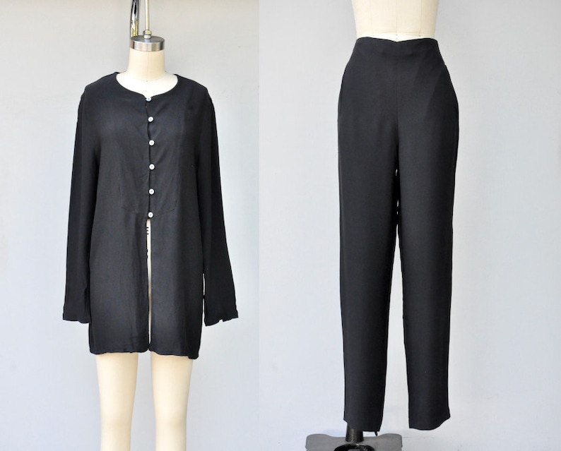May include: A black long-sleeved shirt with a button-up front and a black pair of pants.