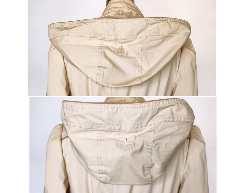 May include: A beige hooded jacket with a zipper closure and a button on the hood. The jacket has a pocket on the hood.