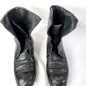 May include: A pair of black leather ankle boots with a folded-down top. The boots have a rounded toe and a slightly distressed look.