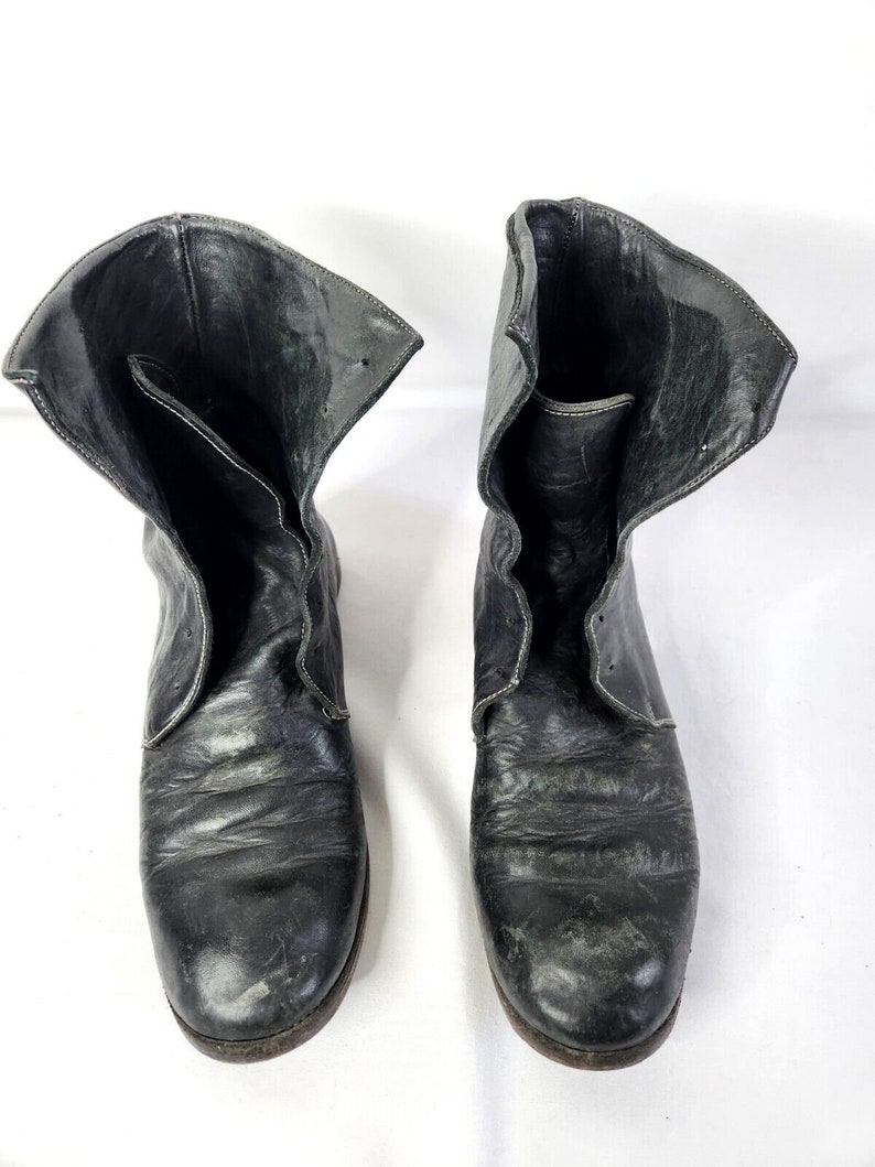 May include: A pair of black leather ankle boots with a folded-down top. The boots have a rounded toe and a slightly distressed look.