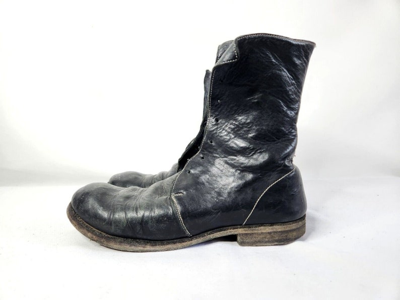 May include: Black leather ankle boots with a lace-up front and a distressed finish.