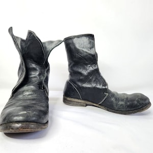 May include: A pair of black leather ankle boots with laces. The boots have a worn look and are made of a distressed leather.