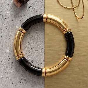 Pulseira robusta em tubo acrílico – detalhes em metal banhado a ouro, ajuste elástico