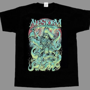 May include: A black short-sleeve t-shirt featuring a graphic print of a bearded pirate in a tricorn hat holding a sword and a mug, surrounded by octopus tentacles. The text ALESTORM is printed in a stylized font above the pirate illustration.