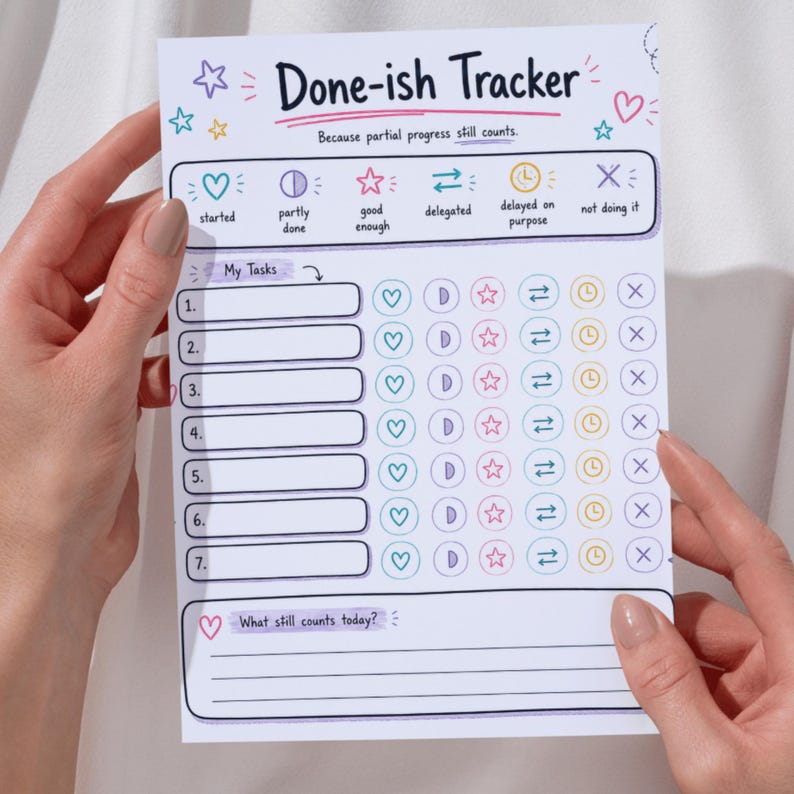 May include: A white paper Done-ish Tracker task list with colorful icons and text. The header reads Done-ish Tracker and Because partial progress still counts. It includes seven numbered rows with columns for status icons like hearts, stars, and clocks.
