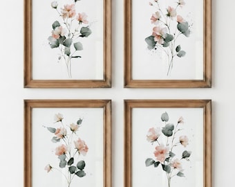 Puede incluir: Un conjunto de cuatro láminas de arte mural enmarcadas, cada una con una ilustración en acuarela de delicadas flores rosas con hojas de color verde apagado sobre un fondo blanco, en marcos de madera sencillos con acabado marrón natural.