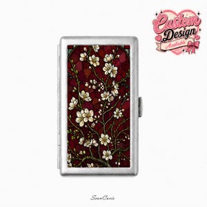 May include: A rectangular silver metal cigarette case featuring a printed design of white almond blossoms on dark red branches against a deep red stained glass background. The top right corner displays a heart-shaped logo with the text Custom Design.