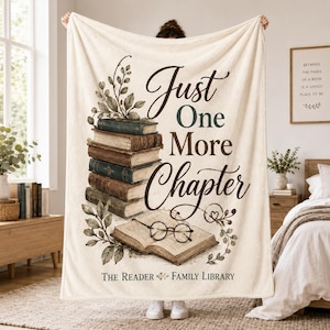 May include: A cream-colored fleece blanket featuring a stack of vintage books, an open book with round spectacles, and leafy branches. The text reads Just One More Chapter and The Reader Family Library in dark brown script and serif fonts.