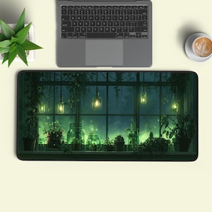 Könnte beinhalten: Eine rechteckige Schreibtischunterlage mit einer dunkelgrünen Illustration eines Fensterblicks, hängenden Glasgefäßleuchten und verschiedenen Topfpflanzen auf einem Sims, platziert unter einem grauen Laptop und einer weißen Kaffeetasse.