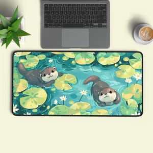 Peut inclure: Un tapis de bureau rectangulaire illustré de deux loutres brunes nageant dans un étang bleu parsemé de nénuphars verts et de petites fleurs blanches. Le tapis présente une bordure noire et est placé sous un ordinateur portable et une tasse.