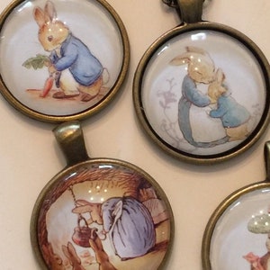 May include: A set of eight round glass pendants featuring illustrations of Peter Rabbit and other characters from Beatrix Potter's children's books. The pendants are attached to bronze-colored chains.