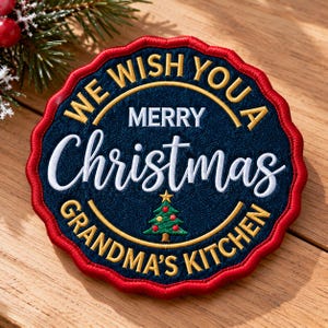 May include: A round embroidered patch with a scalloped red border and a dark blue center. It features gold text reading WE WISH YOU A, white text reading MERRY Christmas, and gold text reading GRANDMA'S KITCHEN with a small green tree.