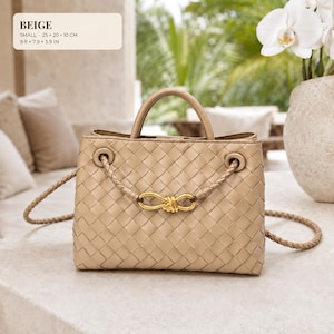 K&ouml;nnte beinhalten: Eine beige geflochtene Ledertasche mit einem Tragegriff und einem geflochtenen Schulterriemen mit goldenem Knotendetail. Die Tasche misst 25 x 20 x 10 cm. Der Text auf dem Bild lautet: BEIGE, SMALL, 25 x 20 x 10 CM, 9.8 x 7.9 x 3.9 IN.