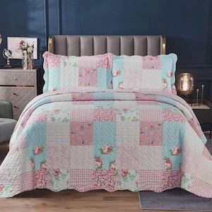 May include: A patchwork quilt and two matching pillow shams featuring a repeating pattern of light blue and pink squares. The design includes floral motifs, gingham checks, and polka dots with a quilted texture throughout the bedding set.
