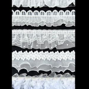 May include: Five horizontal strips of white decorative trim. The top strip is ruffled lace, the second is a scalloped edge with ruffles, the third is lace with small pearls, the fourth is floral lace with pearls, and the bottom is a feathered trim.