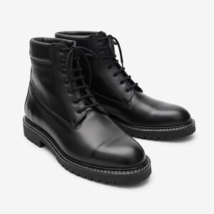 May include: A pair of black leather ankle boots featuring a lace-up front with black laces, a padded collar, and a thick black lug sole with visible white stitching along the welt. The boots have a smooth finish and a rounded toe design.