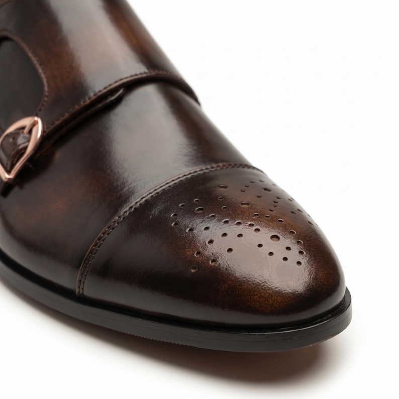 Close-up of hand-burnished patina finish on brown leather cap toe with brogue perforation