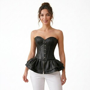 May include: A black strapless corset top crafted from a smooth material, featuring a structured bodice with a vertical row of silver-toned metal hook-and-eye closures down the centre front and a layered, ruffled peplum hem at the waist.