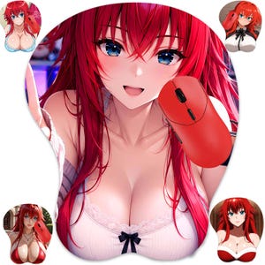 Puede incluir: Una alfombrilla de ratón con un personaje de estilo anime de pelo largo rojo y ojos azules. El personaje lleva un top blanco con ribete de encaje y un pequeño lazo negro. Un ratón de ordenador rojo está sobre el pecho del personaje.