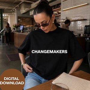 May include: A black short-sleeved t-shirt featuring the word CHANGEMAKERS printed in white capital letters across the chest. The garment is worn with light blue denim jeans and dark-tinted sunglasses. A brown circular graphic states DIGITAL DOWNLOAD.