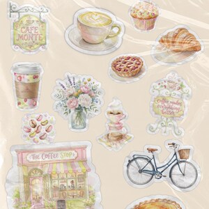 Puede incluir: Una hoja de pegatinas con ilustraciones estilo acuarela de una fachada de cafetería llamada The Coffee Stop, una bicicleta, un latte, un croissant, un muffin, una tarta de bayas, un ramo de flores, granos de café y el texto Cafe Monte.
