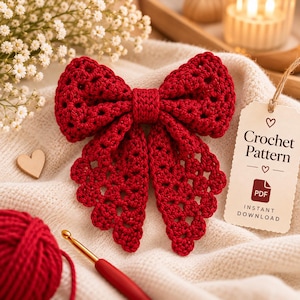 Puede incluir: Un lazo de ganchillo rojo oscuro con un patrón calado, acompañado de una etiqueta que dice Crochet Pattern PDF Instant Download, un ovillo de lana roja y un ganchillo. El lazo presenta un nudo central y dos extremos largos y texturizados.