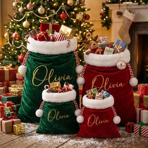 May include: Four velvet Christmas gift sacks in deep green and rich red, each featuring a white faux fur cuff, red and white twisted rope drawstrings with pom-poms, and the name Olivia embroidered in gold script on the front of each sack.