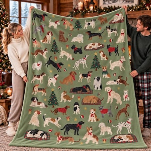 May include: A sage green fleece blanket featuring a repeating pattern of various dog breeds, Christmas trees, and holiday ornaments. The dogs are depicted in different poses, some wearing red scarves or bows, interspersed with small colorful balls.