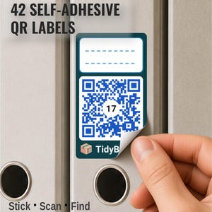Op de afbeelding: Een rechthoekig zelfklevend label met een blauwe QR-code met het nummer 17 in het midden, een witte lege ruimte om op te schrijven aan de bovenkant en de tekst TidyB met een klein icoontje van een doos onderaan, gelabeld 42 SELF-ADHESIVE QR LABELS.